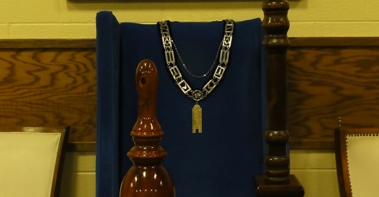 The Junior Warden's Station in the South, with jewel, apron, gavel, and pillar.