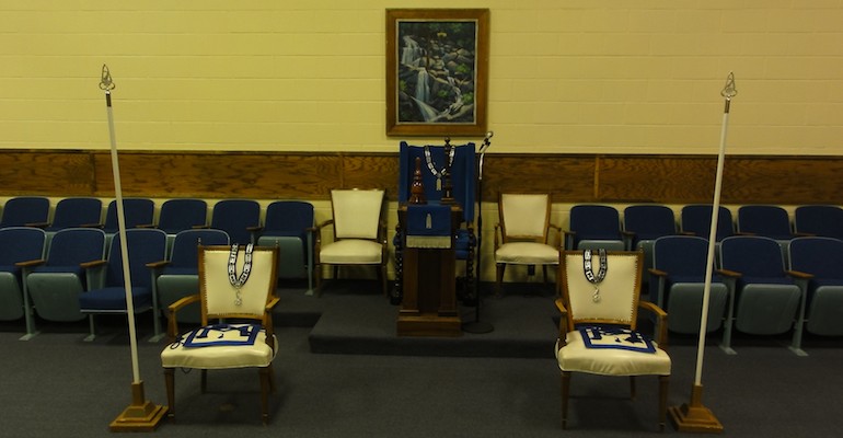 The chairs in the South, with jewels, aprons, rods, pillars, and gavel.